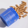 Blue container of MenoMora Embrace with capsules on a light gray background