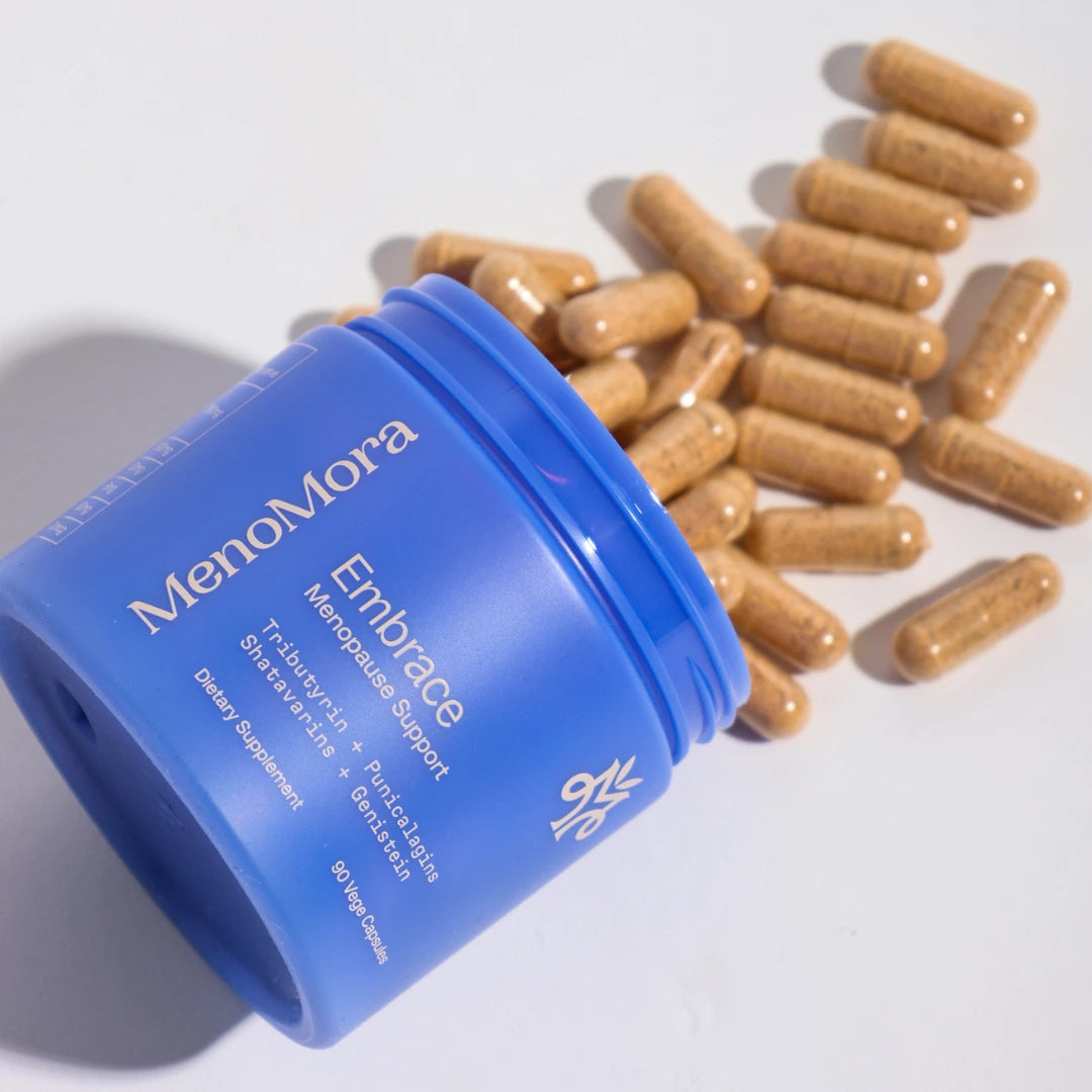 Blue container of MenoMora Embrace with capsules on a light gray background