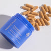 Blue container labeled 'MenoMora' with capsules on a white background