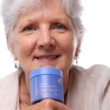 Woman holding MenoMora Thrive postmenopause support supplement